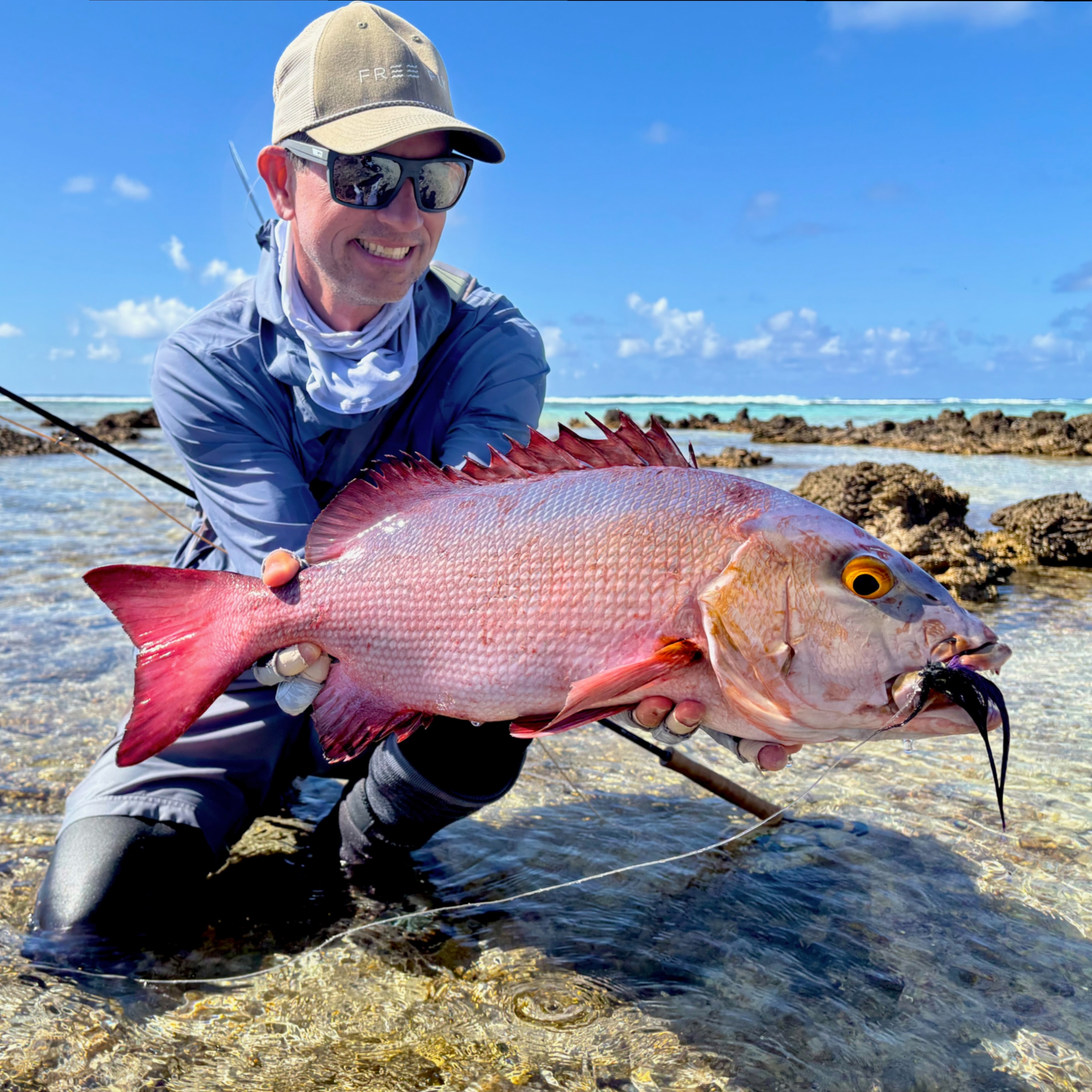Chris Newsome holding red snapper on the flats