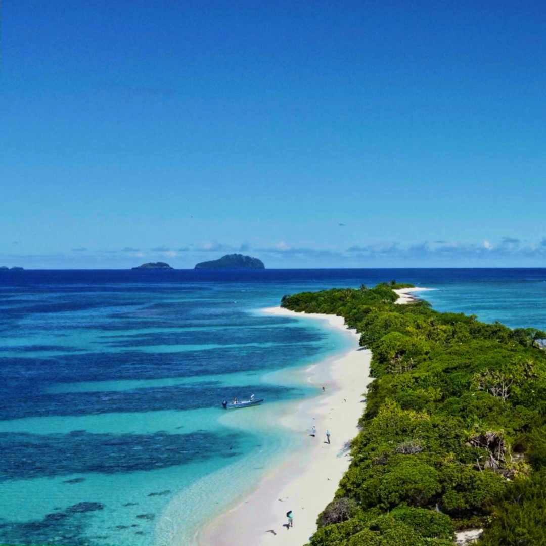 Fly fishing travel in French Polynesia — angler wading crystal-clear tropical flats on an Out Island Odyssey expedition